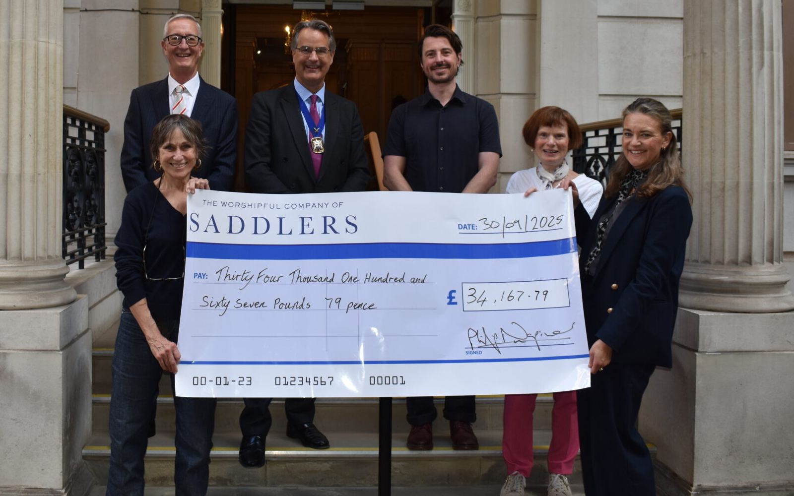 Saddlers' Company members presenting a cheque for £34,167.79 to Shelter from the Storm